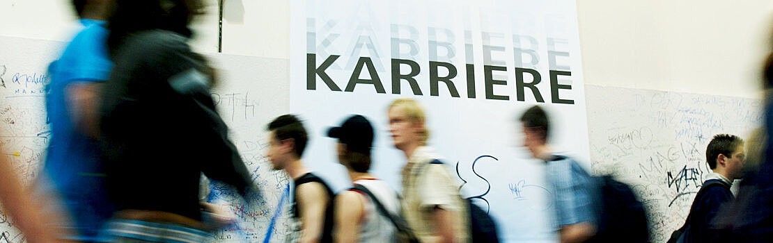 Verschiedene junge Menschen vor "Karriere"-Plakat