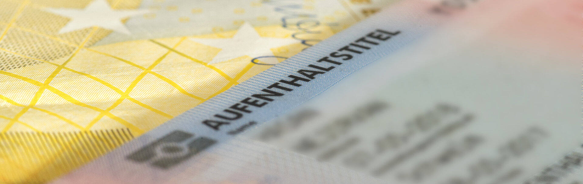 Euro-Geldscheine neben einem Ausweisdokument, die wichtig für einen Aufenthaltsstatus sein können.
